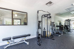 Fully equipped gym with workout machines and weights in spacious apartment community
