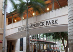 Entrance to Shops at Merrick Park featuring palm trees and elegant architecture in Coral Gables, FL.