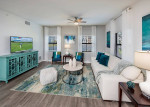 Modern living room in Cape Coral apartments featuring elegant furniture and a large TV