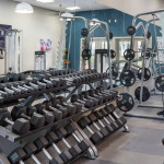 Well-equipped fitness center at Solis At Winter Park, featuring free weights and exercise machines.