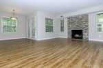 Spacious 1-bedroom apartment living room with hardwood floors, stone fireplace, and natural light in Pasadena.