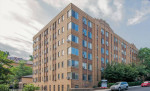 Exterior view of Park Crescent Apartments featuring a brick facade and large windows in Northwest DC.