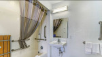Modern bathroom in a Studio 6 extended stay apartment with shower and sink.