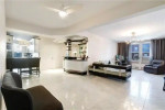 Spacious corner apartment living room with modern decor, large windows, and natural light in Brooklyn.
