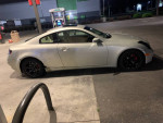 2006 Infiniti G35 Coupe parked at a gas station, featuring custom black rims and red brake calipers.