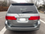 2009 Honda Odyssey minivan rear view with visible dents, ideal for family or business use.
