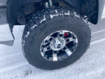 Close-up of Chevrolet Silverado truck wheel and tire in winter conditions, showcasing performance features and rugged design.