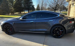 Side view of a 2020 Tesla Model S in Midnight Metallic Gray with black alloy wheels and tinted windows.
