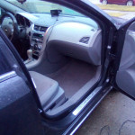 Interior view of a 2011 Chevrolet Malibu, showcasing clean seats and dashboard with automatic controls.