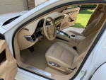 Interior view of a 2011 Porsche Panamera with beige leather seats and modern dashboard design.