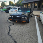 Black 1985 Buick Grand National with upgraded suspension parked on a street during a car event.