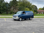 2004 Chevrolet Astro cargo van parked in a spacious lot, featuring a sleek blue exterior and new tires.