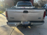 Rear view of a 1998 Ford F150 truck with damage and original owner mileage on display.