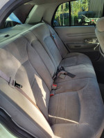 Interior view of the back seat in a 2001 Crown Victoria, featuring gray fabric seats and seat belts.
