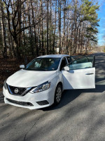 2017 Nissan Sentra in excellent condition with open door, 140,000 miles, parked in wooded area.