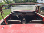 Interior view of a 1962 MG Midget convertible, in need of restoration and selling for parts.