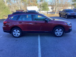 2016 Subaru Outback with low mileage, all-wheel drive, parked in a lot surrounded by trees and vehicles.