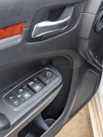 Interior door controls of a 2014 Chrysler 300 showcasing window switch features.
