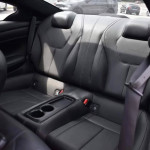 Interior view of the INFINITI Q60 coupe, showcasing stylish black leather rear seats and center console.