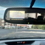 Rear-view camera display in a 2013 Subaru Outback showing parking guidance lines.