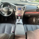 Interior view of 2013 Subaru Outback 2.5i with black leather seats and dashboard features.
