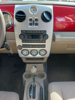Interior view of a 2006 Chrysler PT Cruiser showing dashboard and controls with red accents.