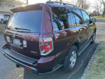 2007 Honda Pilot EX-L FWD parked, showcasing its maroon exterior and well-maintained condition.