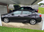 2014 Chevrolet Cruze 1LT parked in shaded area, showcasing its sleek design and good condition.