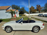 1999 Mazda MX-5 Miata Touring Package with 115k miles parked in a residential area