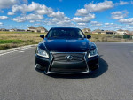 Front view of a 2013 Lexus LS 460 L parked on a road with blue skies and clouds