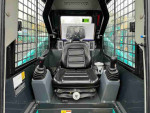 Interior view of a compact excavator with a comfortable seat and control levers, ideal for heavy-duty tasks.