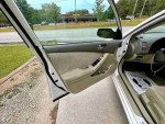 Interior view of a 2008 Nissan Altima 2.5 with leather seats and clean design, door open showing spacious cabin.