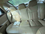 Backseat of a 2012 Chevrolet Impala LS with beige leather upholstery and seat belts.