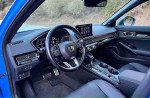 Interior view of the 2024 Honda Civic Sport hatchback showcasing the dashboard and seating.