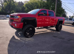 2016 Chevrolet Silverado 1500 Rocky Ridge in red with aggressive off-road features and lifted stance, parked outdoors.