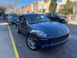 Black 2015 Porsche Macan S AWD parked on a city street, showcasing its sleek design and upscale features.