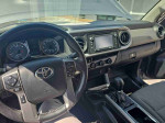 Interior view of a 2016 Toyota Tacoma with steering wheel and dashboard features