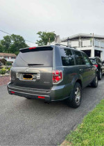 2007 Honda Pilot EX-L 4WD parked, showcasing its rear with minor scratches and good condition