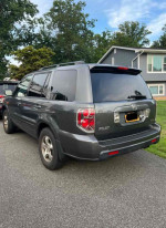 2007 Honda Pilot EX-L in fair condition parked on the driveway, showing dings and scratches.
