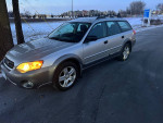 2007 Subaru Outback on a snowy road, featuring winter tires and a silver exterior.