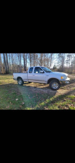 1997 Ford F-150 Lariat 4WD truck parked on grass, showcasing its exterior and short bed design.