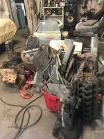Tools and car parts for a 1959 Jaguar XK150 restoration in a cluttered garage setting.