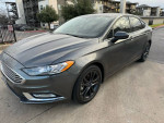 2018 Ford Fusion with low miles and a sleek design parked outside an apartment complex.