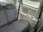 Interior view of a 2008 Dodge Grand Caravan showing back seat with seat belts and cup holders.