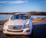 Front view of a well-maintained 2010 Mercedes-Benz ML-350 parked near a lake.