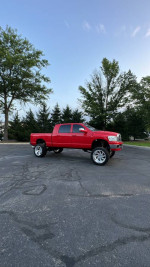 2006 Dodge Ram 2500 Mega Cab truck for sale, red with custom wheels and suspension, in excellent condition.