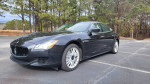 2014 Maserati Quattroporte S Q4 in black, parked amidst trees, showcasing its sleek design and clean exterior