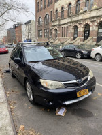 2009 Subaru Impreza Outback Sport AWD parked on the street, showcasing its sleek design and reliable features.