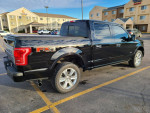 2016 Ford F-150 Platinum 4WD with Shadow Black exterior parked in front of a hotel