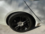 Close-up of the wheel and tire of a 2009 Genesis sedan with a black alloy rim.